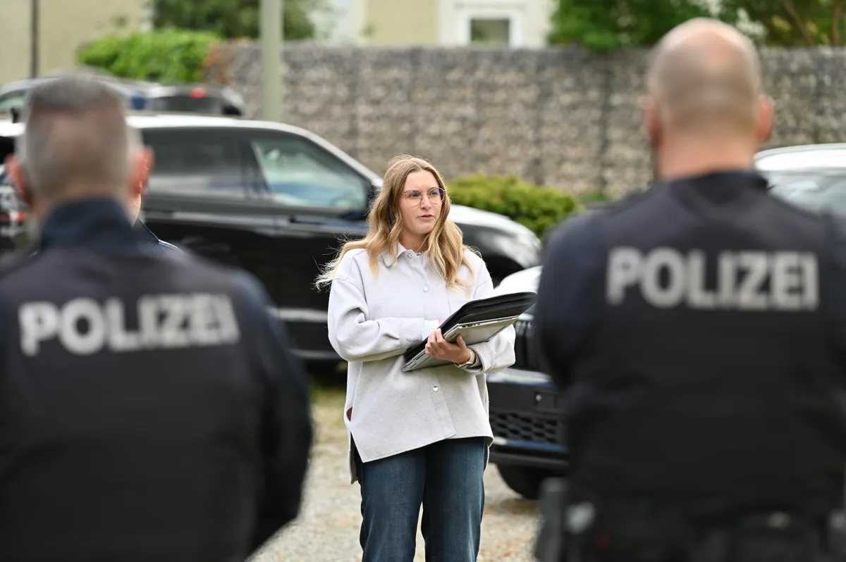 Man sieht eine Frau und zwei Polizisten.
